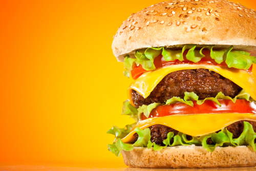 Tasty and appetizing hamburger on a yellow background